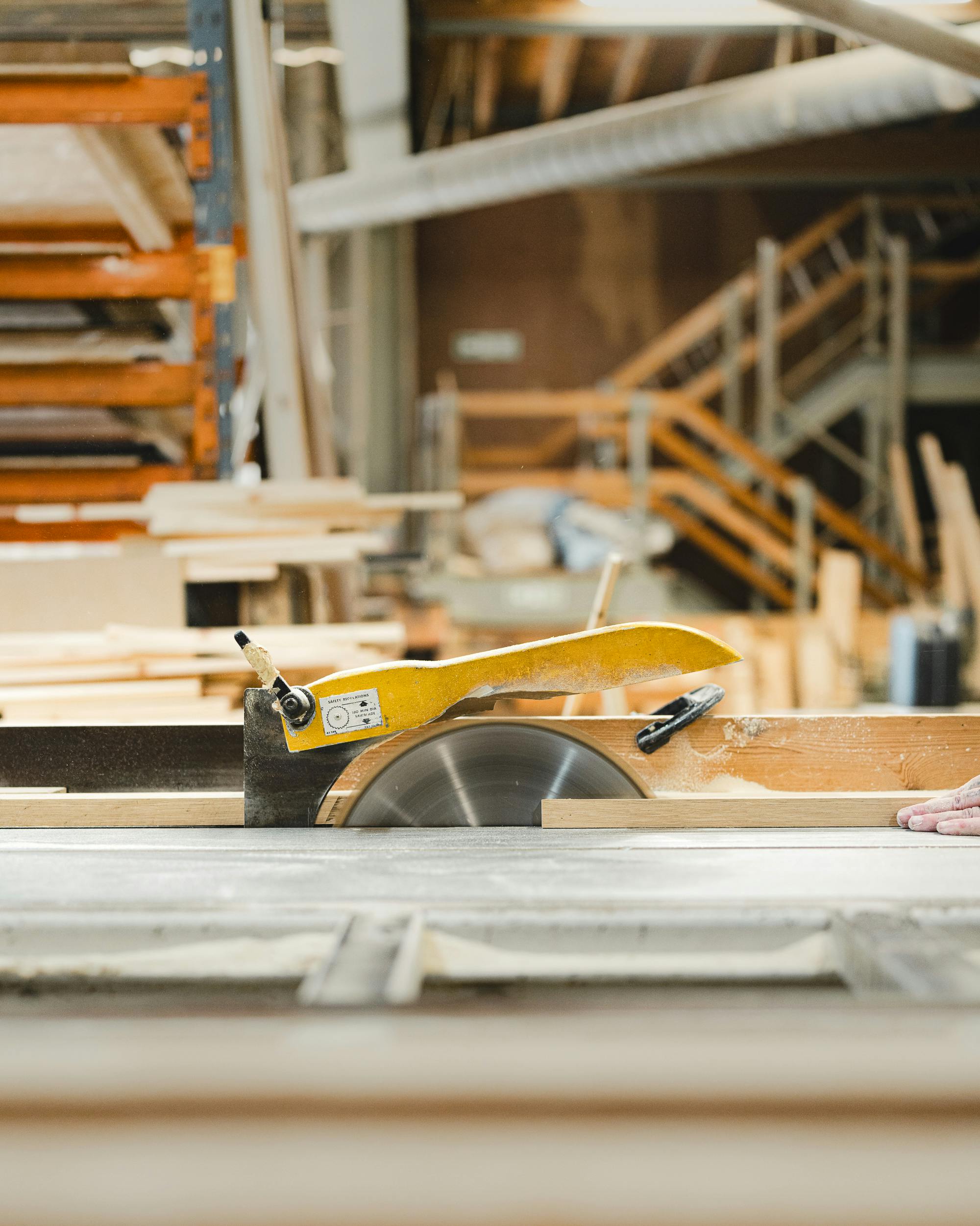 Circular saw and wood planks in a busy carpenter's workshop. Industrial mood.